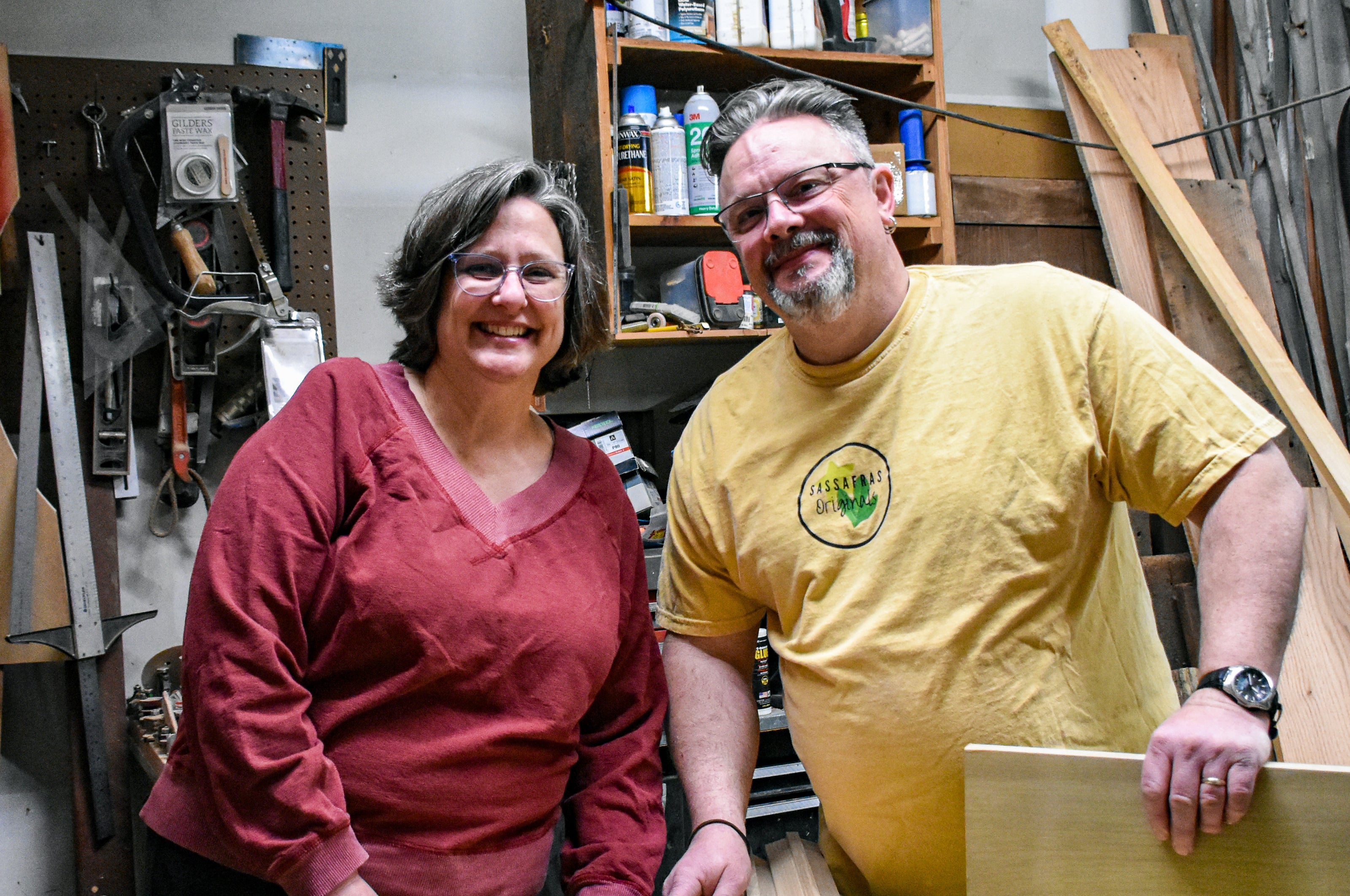 The owners in their garage where Christopher makes wood bowls and boards